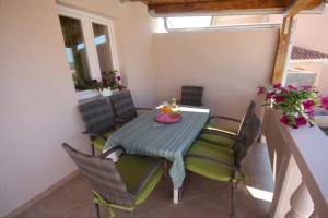 un tavolo da pranzo con sedie in una camera con balcone di Apartment Rustica with 2 bedrooms a Ljubač