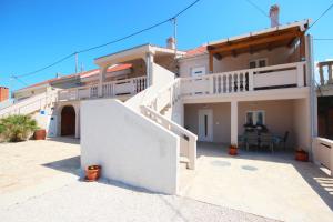 una grande casa bianca con balcone e patio di Apartment Rustica with 2 bedrooms a Ljubač
