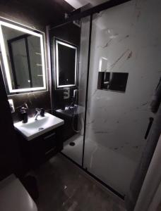 a bathroom with a shower and a sink and a mirror at Apartament Heaven in Ełk