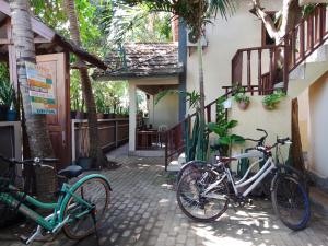 two bikes parked next to a building with trees at Mangga homestay Gili air in Gili Air