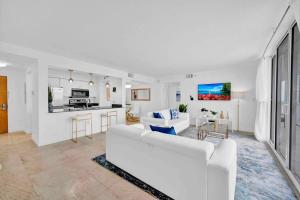 a living room with a white couch and a kitchen at 40th Floor Priceless Unit Central Location in Miami