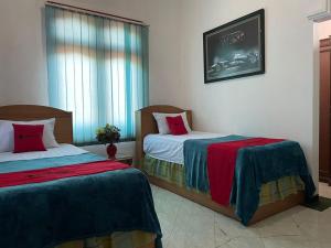a bedroom with two beds and a window at RedDoorz Syariah @ Karang Pilang in Karangpilang +49 photos
