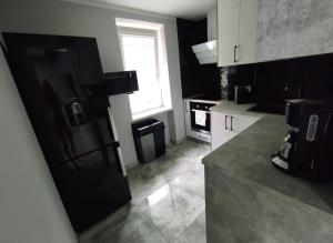 a kitchen with a black refrigerator and a window at Apartament Heaven in Ełk