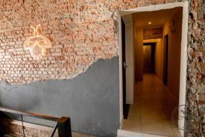 a brick wall with a chandelier in a hallway at ISONDU Suites & Breakfast in Puerto Iguazú