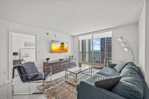 a living room with a blue couch and a balcony at High Floor Ocean view Unit In Brickell in Miami