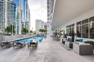 a pool in a building with chairs and tables at High Floor Ocean view Unit In Brickell in Miami