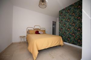 ein Schlafzimmer mit einem Bett mit einer gelben Decke in der Unterkunft Casa Viturna in O Grove