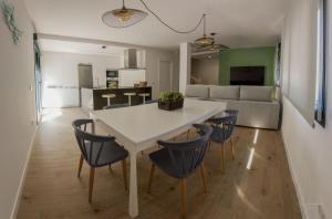a kitchen and living room with a white table and chairs at Casa Viturna in O Grove