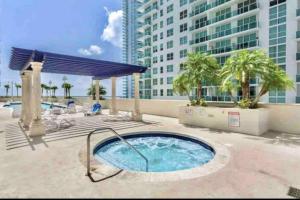 - un bain à remous sur une terrasse avec un bâtiment dans l'établissement Amazing location W Parking in Miami, à Miami