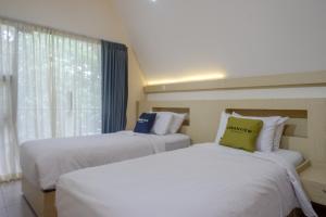NgaglikにあるUrbanview Resort Kampoeng Media Yogyakarta by RedDoorzのベッド2台 ホテルルーム 窓付