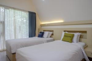 Postel nebo postele na pokoji v ubytování Urbanview Resort Kampoeng Media Yogyakarta by RedDoorz