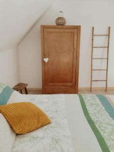 1 dormitorio con 1 cama y puerta de madera en LOFT Le chant des Oiseaux proche Mont St Michel, en Pleine-Fougères