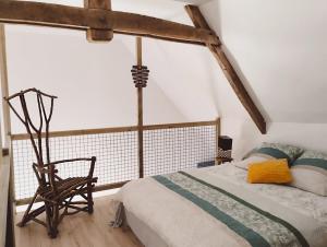 sypialnia z łóżkiem i drewnianym krzesłem w obiekcie LOFT Le chant des Oiseaux proche Mont St Michel w mieście Pleine-Fougères