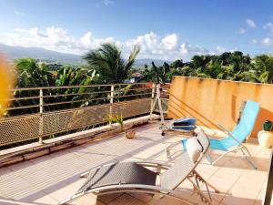 a balcony with chairs and a view of the mountains at Grand Appartement de Standing, Appt Entier , ou , Chambre en colocation, Magnifique vue Mer in Ducos