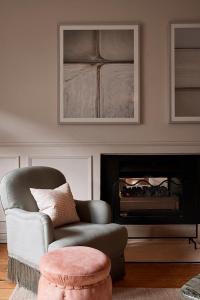 a living room with a chair and a fireplace at Osborn House in Bundanoon