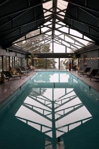 a swimming pool in a building with a glass ceiling at Osborn House in Bundanoon