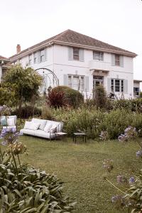 - un canapé blanc dans une cour devant une maison dans l'établissement Osborn House, à Bundanoon