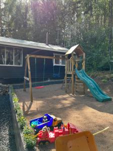 a playground with a slide and play equipment in a yard at Villa Safari in Perniö