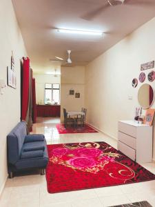 uma sala de estar com um tapete vermelho e uma cadeira azul em QQ HOMESTAY BACHOK KANDIS em Bachok