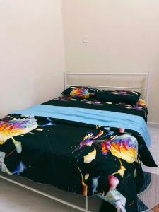 ein Schlafzimmer mit einem Bett mit einer schwarzen Bettdecke in der Unterkunft QQ HOMESTAY BACHOK KANDIS in Bachok