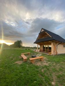 a building with a picnic table in a field at Góralskie Domki u Topora in Czarny Dunajec