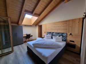 sypialnia z dużym białym łóżkiem w pokoju w obiekcie Greidlhof Alpstyle Apartments w mieście Fügen