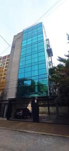 a glass building with a car parked in front of it at Ombu Loft Olivos, Vista al Rio in Olivos