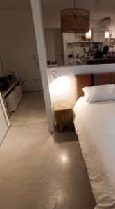 1 dormitorio con 1 cama con taburete de madera al lado en Ombu Loft Olivos, Vista al Rio in 