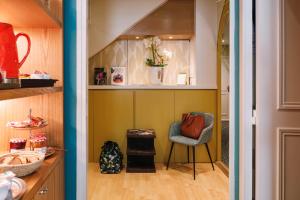 a walk in pantry with a chair and a vase of flowers at Hôtel du Dauphin in Lyon