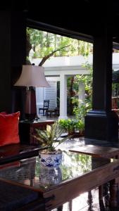 a living room with a glass table and a lamp at Makka Hotel in Chiang Mai