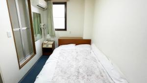 - une petite chambre avec un lit et une fenêtre dans l'établissement Business Hotel Rupinasu, à Takamatsu