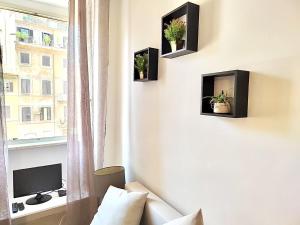 um quarto com um sofá, uma televisão e uma janela em Trastevere Rome’s Heart charming apartment 88 em Roma