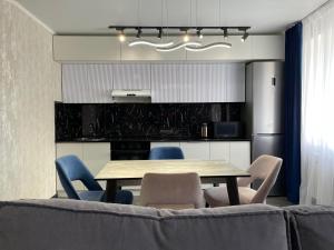 a dining room with a table and chairs at Новостройка с дизайнерским ремонтом in Petropavlovsk +6 photos