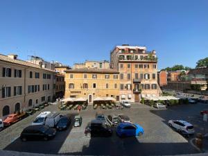 um parque de estacionamento com carros estacionados em frente a um edifício em Trastevere Rome’s Heart charming apartment 88 em Roma