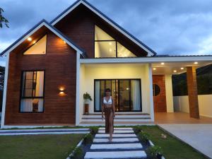 a woman standing in front of a house at Sleep private khaoyai in Mu Si