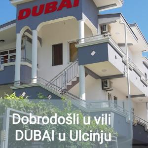 un edificio con un cartello di fronte di Vila DUBAI - ULCINJ VELIKA PLAŽA a Ulcinj