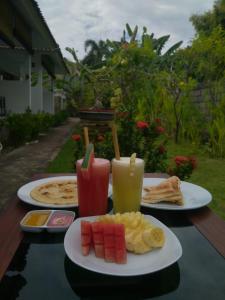 einen Tisch mit zwei Speisen und Getränken in der Unterkunft Murni house in Ambat
