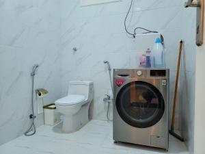 a bathroom with a washing machine and a toilet at دور فخم ومتكامل بالقرب من عسير مول in ‘Aryam