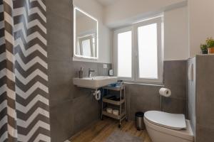 uma casa de banho com um lavatório, um WC e um espelho. em Moderne & schöne Apartments zwischen Altstadt und Stadtpark em Nurembergue