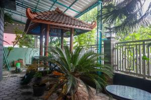 a garden with a gazebo and a palm tree at RedDoorz Syariah near RS Mitra Siaga in Tegal