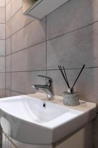 La salle de bains est pourvue d'un lavabo, d'un robinet et d'un miroir. dans l'établissement Apartments24 Ilu, à Rakvere
