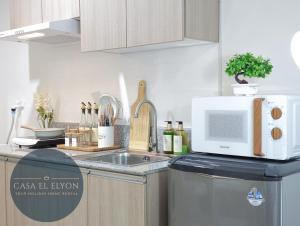 a kitchen with a sink and a microwave at White Nordic Fully-Furnished Studio at INSPIRIA in Davao City