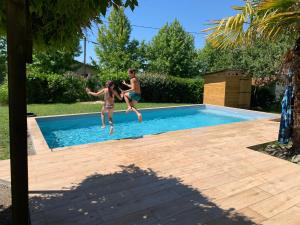 a group of people jumping into a swimming pool at Les Taouleres in Hastingues