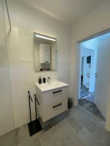a white bathroom with a sink and a mirror at Sorinas Unterkunft WB16 Top 13 
