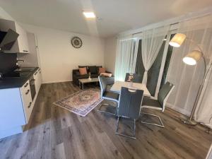 a kitchen and a living room with a table and chairs at Sorinas Home - Comfortable Apartment near Graz - Free Parking in Wagersbach