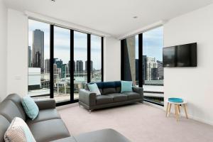 a living room with a couch and a flat screen tv at Waterfront Melbourne Apartments in Melbourne