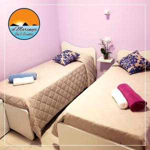 2 camas en una habitación con un cartel en la pared en B&B aMarineja en Nicotera Marina