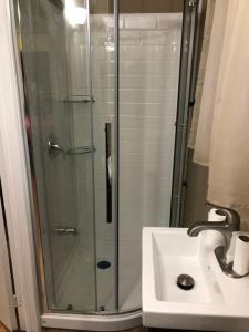 a shower with a glass door next to a sink at Wasaga Bridge Cottages in Wasaga Beach +42 photos