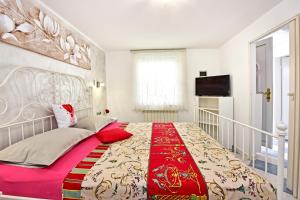 Un dormitorio con una cama grande con una manta roja. en Apartments Rimac 663, en Poreč