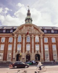 a tall building with a clock on the front of it at Villa Copenhagen in Copenhagen